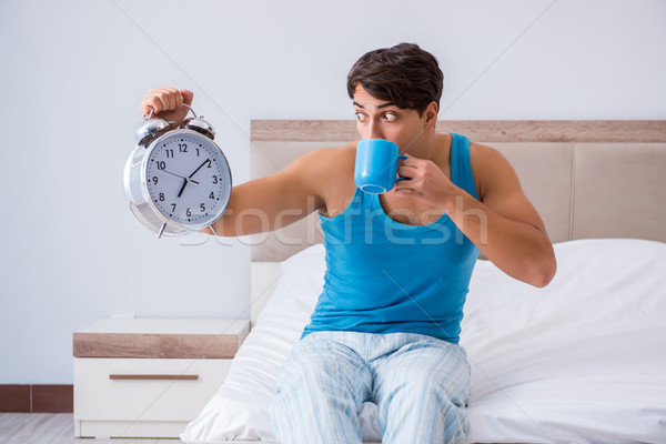 Young man waking up in bed Stock photo © Elnur