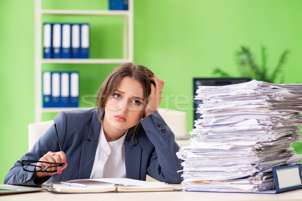 Young female employee very busy with ongoing paperwork Stock photo © Elnur