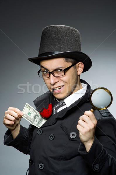 Young detective in black coat with money against gray Stock photo © Elnur