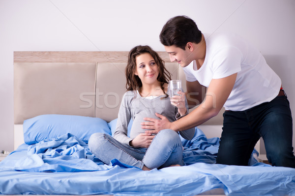 Young family with pregnant wife expecting baby in bed Stock photo © Elnur
