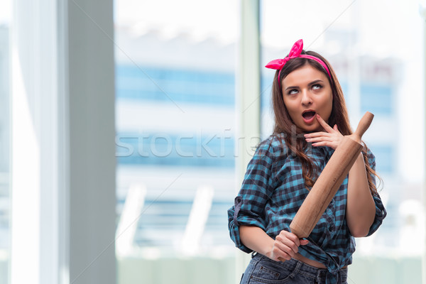 Stock photo: Woman with rolling pin in the kitchen