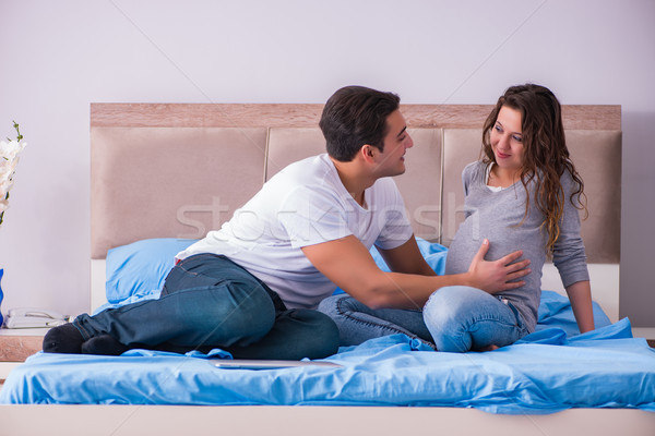 Young family with pregnant wife expecting baby in bed Stock photo © Elnur