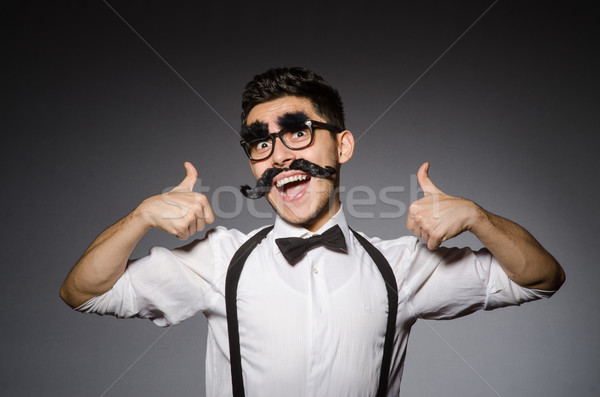 Young caucasian man with false moustache against gray Stock photo © Elnur