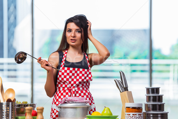 Young cook preparing soup in the kitchen Stock photo © Elnur