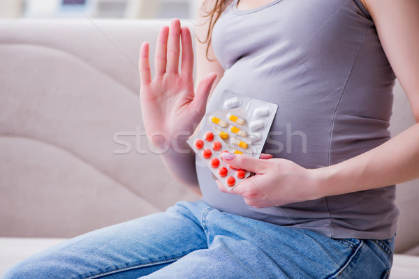 Pregnant woman with a belly tummy sitting on a sofa at home Stock photo © Elnur