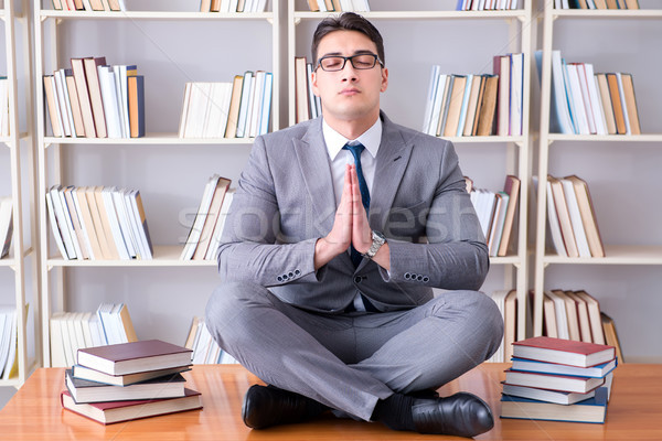 Businessman student in lotus position concentrating  in the libr Stock photo © Elnur