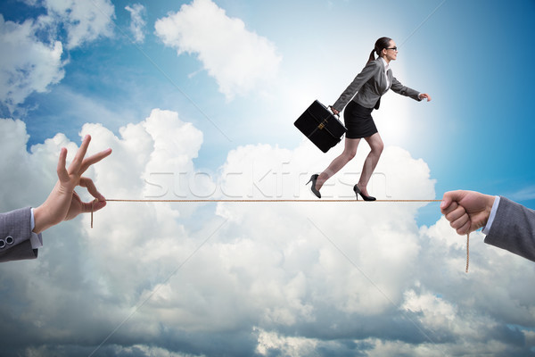 Businesswoman walking on tight rope in business concept Stock photo © Elnur