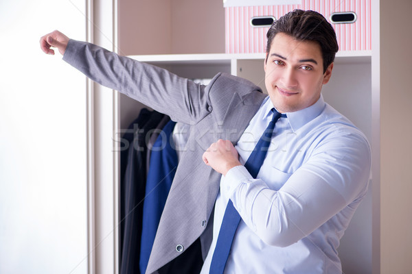 Stock photo: Young man businessman getting dressed for work