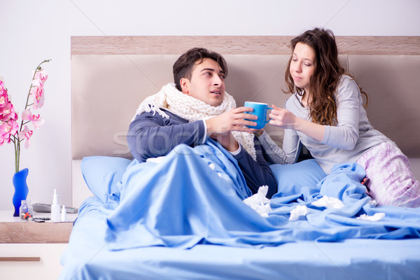Wife caring for sick husband at home in bed Stock photo © Elnur
