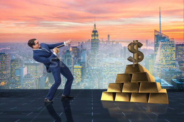 Businessman pulling dollar and gold bullions Stock photo © Elnur
