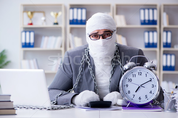 Bandaged businessman worker working in the office doing paperwor Stock photo © Elnur