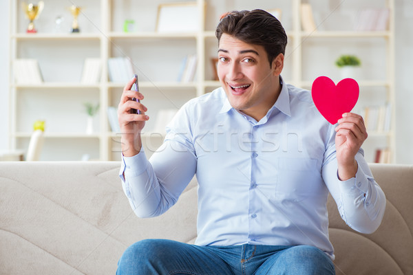 Young man chatting with his sweetheart over mobile phone Stock photo © Elnur
