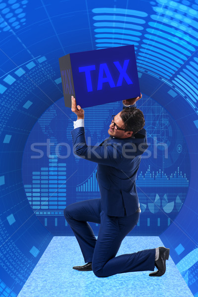 Stock photo: Man under the burden of tax payments