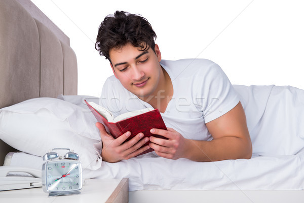 Homem cama sofrimento insônia livro feliz Foto stock © Elnur