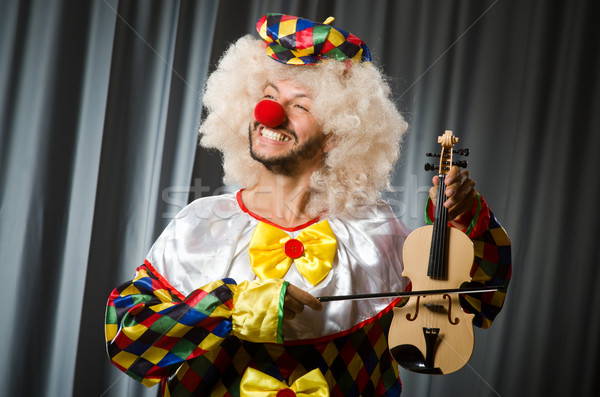 Funny clown plyaing violin against curtain Stock photo © Elnur