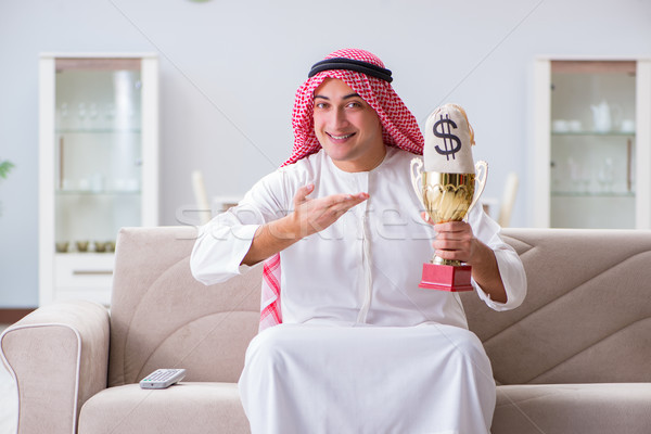 Stock photo: Arab man with prize and money on sofa