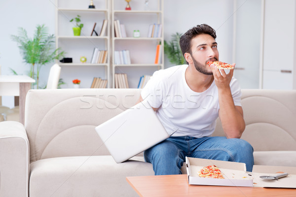 Man eating pizza having a takeaway at home relaxing resting Stock photo © Elnur