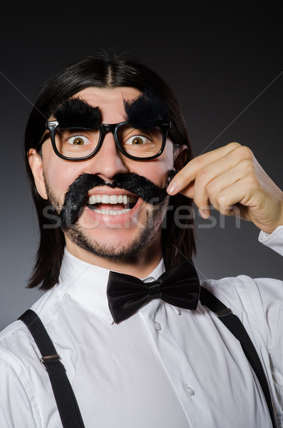 Young man with false mustache and eyebrows isolated on gray Stock photo © Elnur