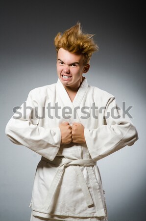 Stock photo: Funny karate fighter with nunchucks on white