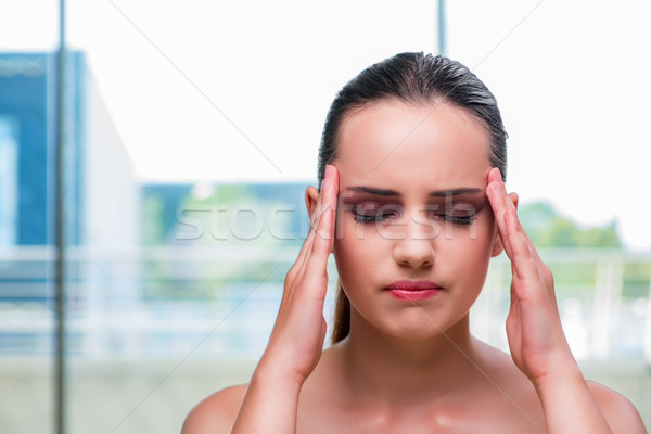 Young woman holding her temples with headache Stock photo © Elnur