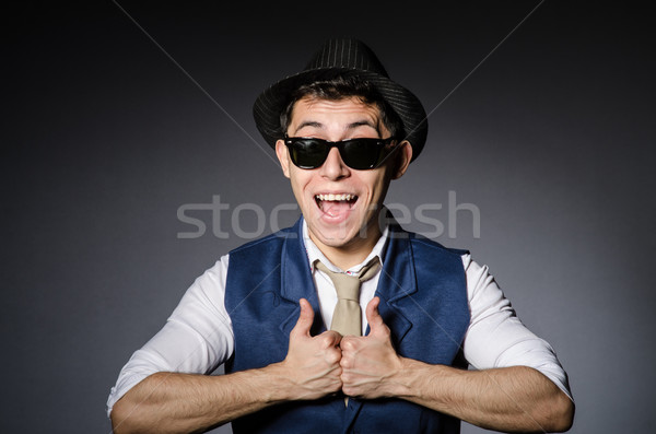 Stock photo: Young man in blue vest and hat against gray