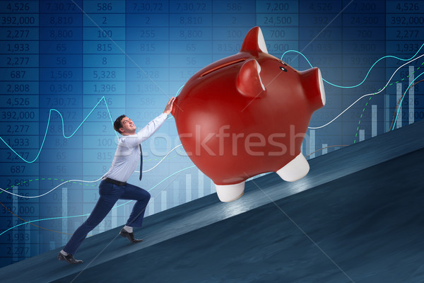 Man pushing piggybank uphill in business concept Stock photo © Elnur