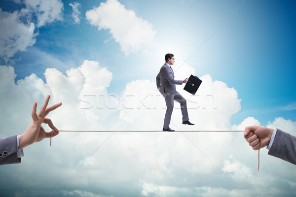 Businessman walking on tight rope in business concept Stock photo © Elnur