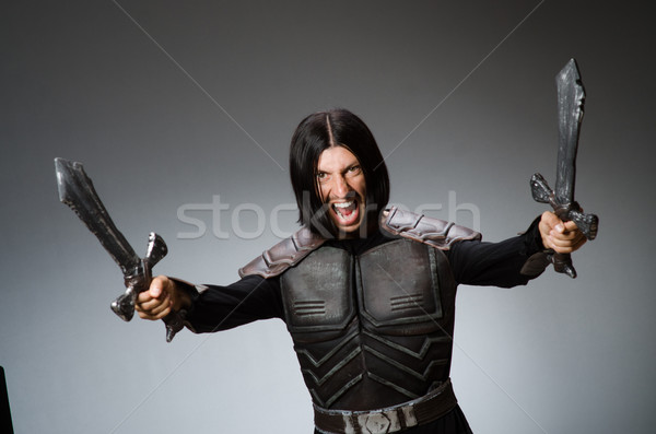 Angry knight with sword against dark background Stock photo © Elnur