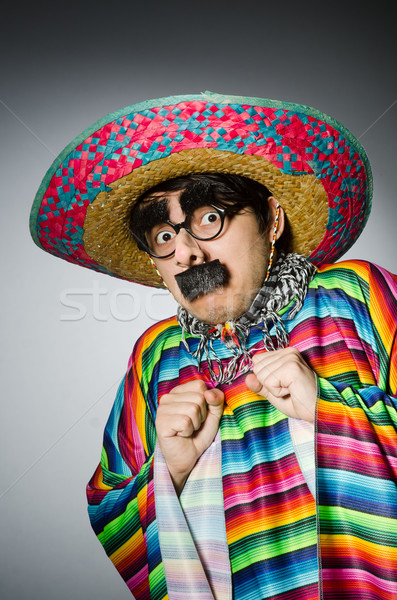 Stock photo: Man in vivid mexican poncho against gray