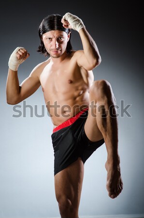 Stock photo: Muscular man in dark studio