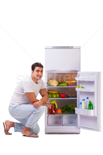 Stock photo: Man next to fridge full of food