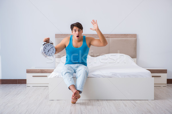 Młody człowiek w górę bed pracy spać sypialni Zdjęcia stock © Elnur