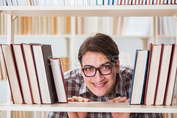 Foto stock: Jovem · estudante · olhando · livros · faculdade · biblioteca