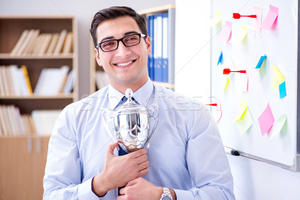 Young businessman receiving prize cup in office Stock photo © Elnur