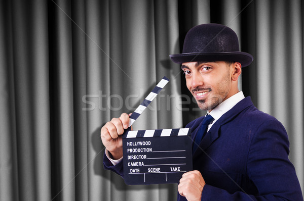 Stock photo: Man with movie clapper on curtain background