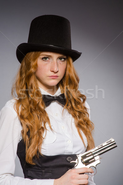 Pretty girl wearing retro hat and holding weapon isolated on gra Stock photo © Elnur