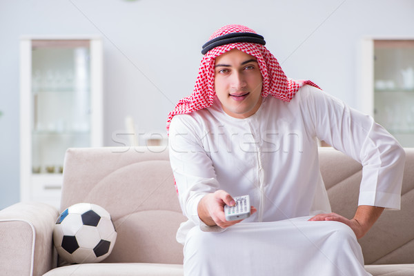 Stock photo: Arab man watching sport football at tv