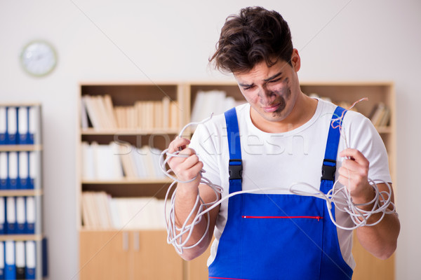 The funny young electrician tangled in cables Stock photo © Elnur
