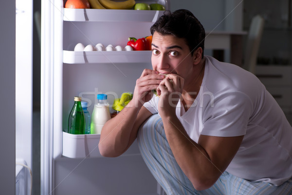 Férfi hűtőszekrény eszik éjszaka ház étel Stock fotó © Elnur