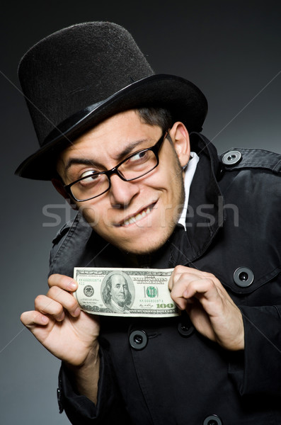 Young man in black coat holding money against gray Stock photo © Elnur
