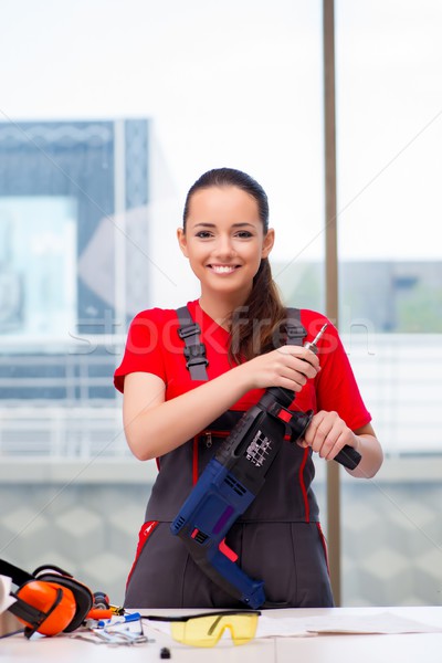 Young woman in coveralls doing repairs Stock photo © Elnur