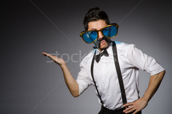 Young man with false moustache and large sunglasses isolated on gray Stock photo © Elnur