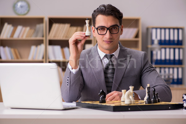 Young businessman playing chess in the office Stock photo © Elnur
