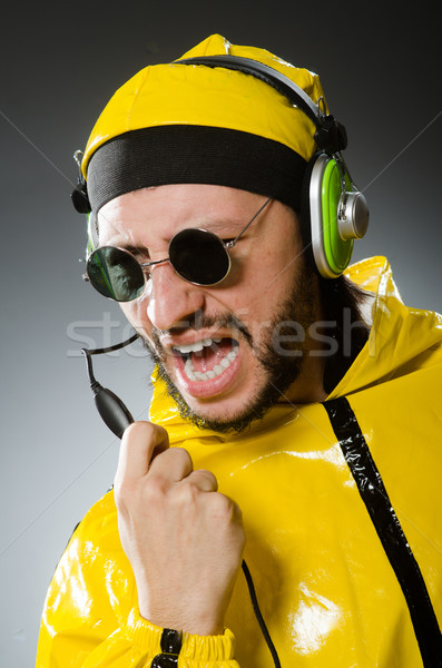 Homem amarelo terno escuta fones de ouvido Foto stock © Elnur