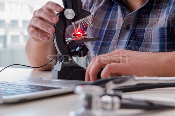 High precision engineering with man working with microscope Stock photo © Elnur