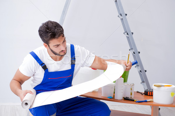 Repairman doing renovation repair in the house with paper wallpa Stock photo © Elnur