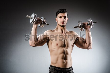 Ripped man with gun against grey background Stock photo © Elnur