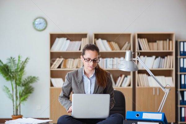 Busy angry businesswoman sitting on the desk in office Stock photo © Elnur