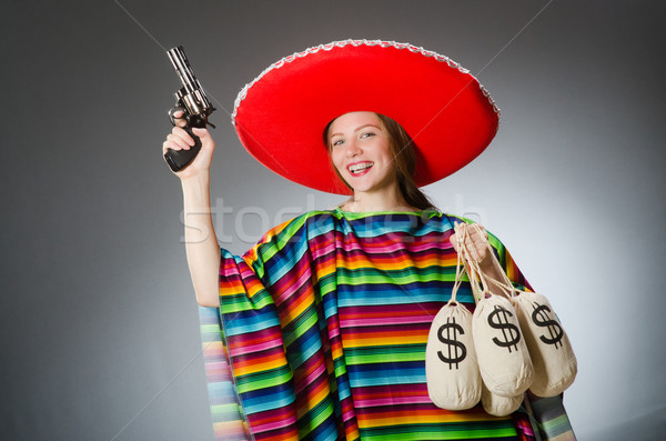 Girl in mexican poncho holding handgun and money sacks against g Stock photo © Elnur