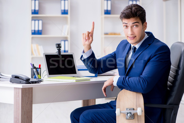 Young businessman with skate in office in sports concept Stock photo © Elnur